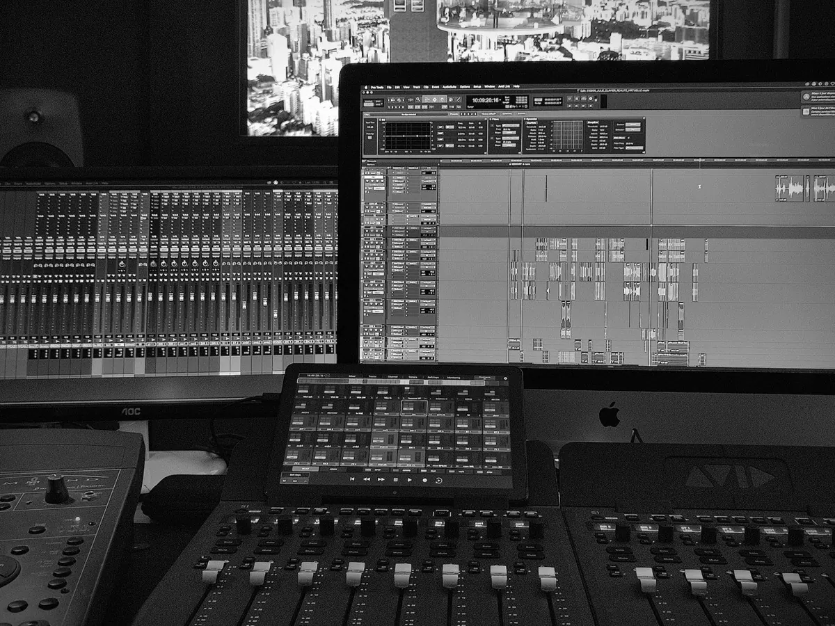 La régie du studio : console de mixage, surface de contrôle et session Pro Tools
                à l'écran.